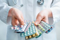 Ein Arzt hält mehrere Sorten Tabletten