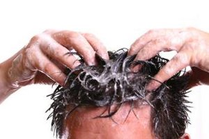 Mann wäscht sich die Haare mit Shampoo