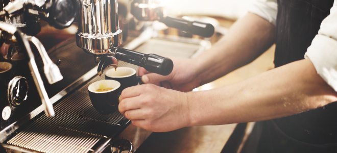 Mann bereitet Kaffee an Kaffeemaschine zu