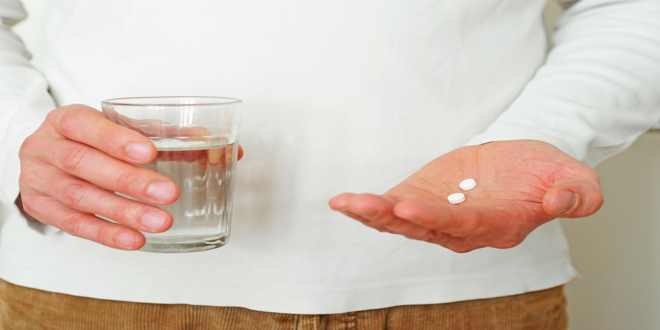 Medikamente und ein Glas Wasser