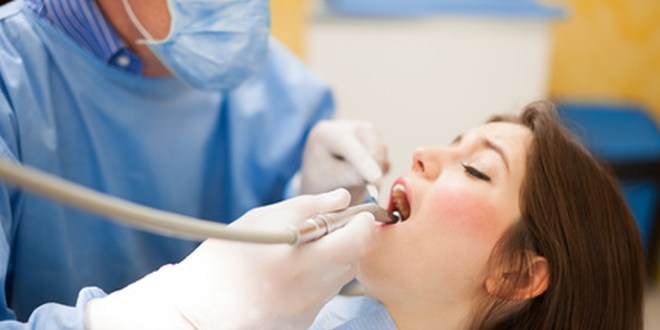 Zahnarzt führt Eingriff im Mund einer Frau durch