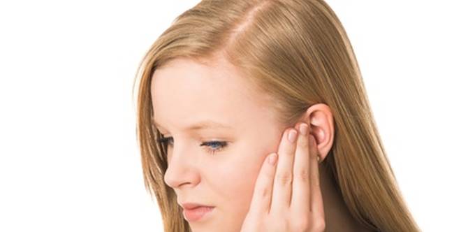 Frau hält ihre Hand am Ohr, weil es wegen Eiter im Ohr wehtut