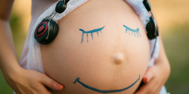 Schwangere mit Smiley auf dem Bauch