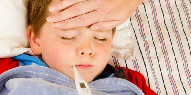 Ein Kind hat Fieber und bei ihm wird die Temperatur gemessen.
