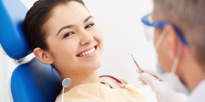 Frau sitzt im Stuhl bei einem Zahnarzt, weil sie Karies am Weisheitszahn preventiv vorbeugen möchte