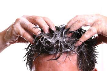 Schuppenflechte der Kopfhaut Mann wäscht sich die Haare mit Shampoo
