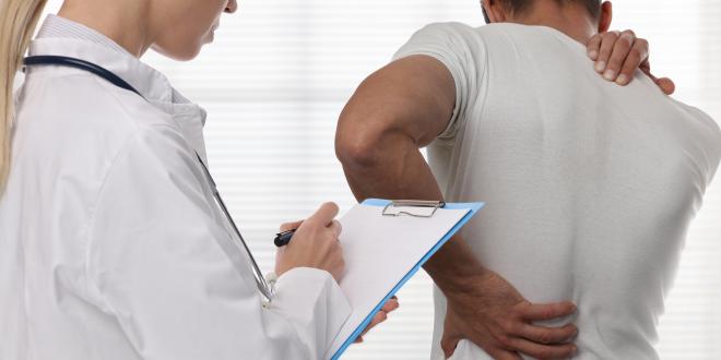 Rückenschmerzen - Was kann man tun? Patient mit Rückenschmerzen